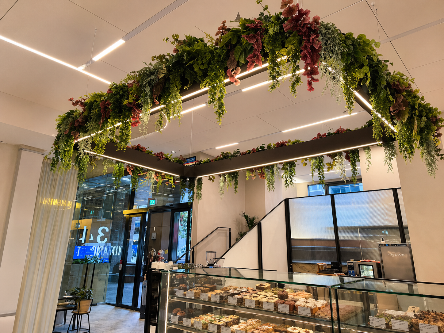 Coffee Mark interior with greenery, lights, and cabinet counter